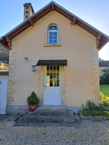 a small house with a white door at La Maison Pelloquin in Bernières-sur-Mer