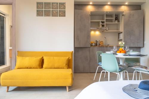 a living room with a yellow couch and a table at L'Arancio e i Pesci Rossi in Calatabiano