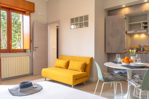 a living room with a yellow chair and a table at L'Arancio e i Pesci Rossi in Calatabiano
