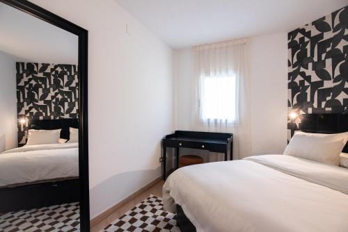 a bedroom with two beds and a mirror at Casa Jasmine Family Villa near the beach in Barcelona