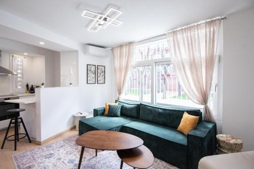 a living room with a green couch and a table at Casa Jasmine Family Villa near the beach in Barcelona