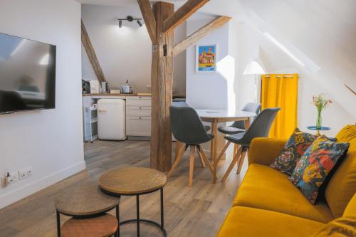 un salon avec un canapé jaune et une table dans l'établissement Mia Cambro, à Tournus