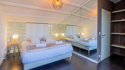 - une grande chambre avec 2 lits et un miroir dans l'établissement Les Cygnes - exceptional location with lake view - 3 bedrooms, à Aix-les-Bains