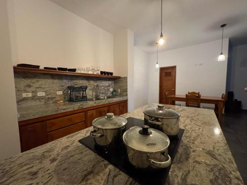 two pots on top of a stove in a kitchen at Suite Golden Beach in Puerto Villamil