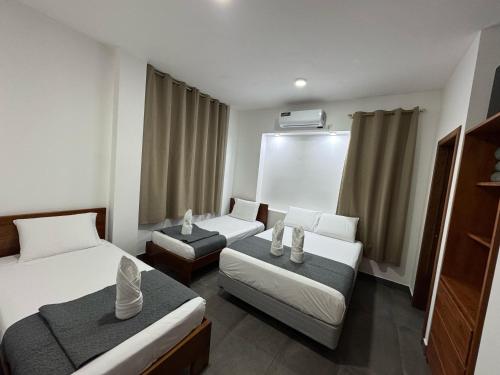 a hotel room with two beds and two chairs at Suite Golden Beach in Puerto Villamil