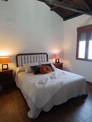 a bedroom with a large white bed with two lamps at Casa Rural Gafas in El Toboso