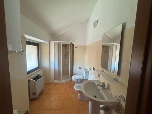 a bathroom with a sink and a toilet and a mirror at Emma Lake Apartment lago di Viverone in Viverone