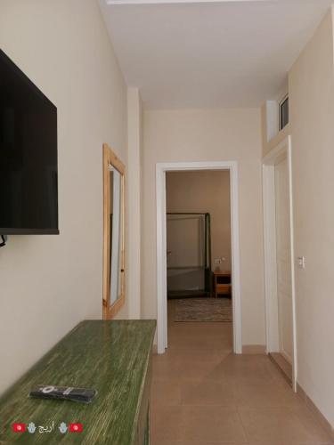 a living room with a table and a flat screen tv at Résidence Tozeur Almadina chambres Supérieures in Tozeur