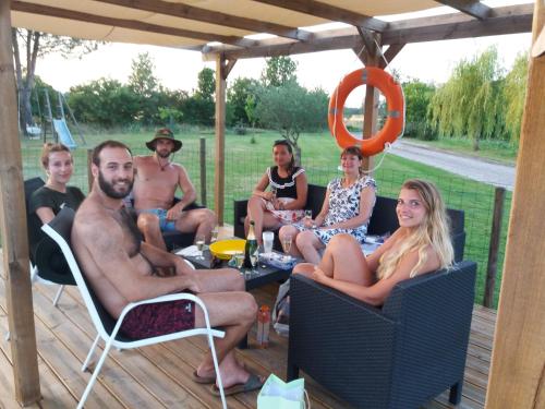 a group of people sitting in chairs on a deck at Gîtes de La Carrétarié in Parisot