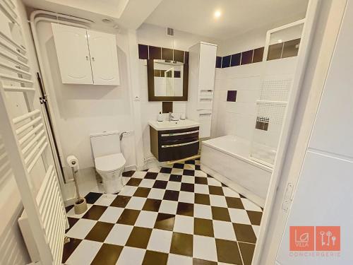 La salle de bains est pourvue d'un sol en damier noir et blanc. dans l'établissement Le Ferber, à Wimereux