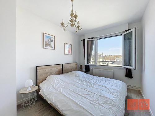 une chambre blanche avec un lit et une fenêtre dans l'établissement Le Ferber, à Wimereux