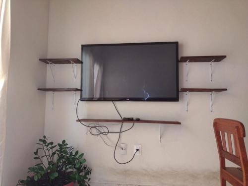Toledo Damasco House في إيتاكاري: تلفزيون بشاشة مسطحة معلق على جدار مع رفوف