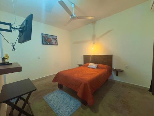 a bedroom with a bed and a ceiling fan at Casa Majagua in Brisas de Zicatela