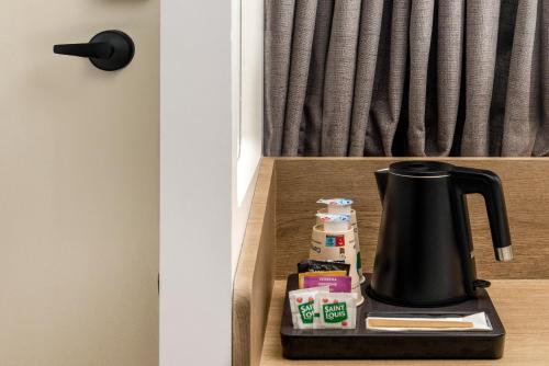 a tea kettle on a shelf in a room at Campanile NATURE - Bordeaux Lac in Bordeaux