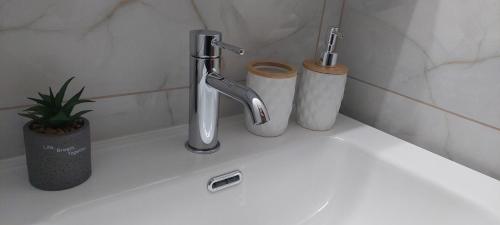 a bathroom sink with a faucet and two toilets at The Arch Nest in Kavala