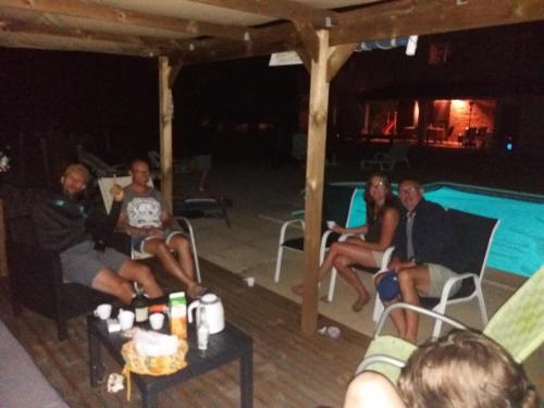 a group of people sitting in chairs next to a pool at Gîtes de La Carrétarié in Parisot