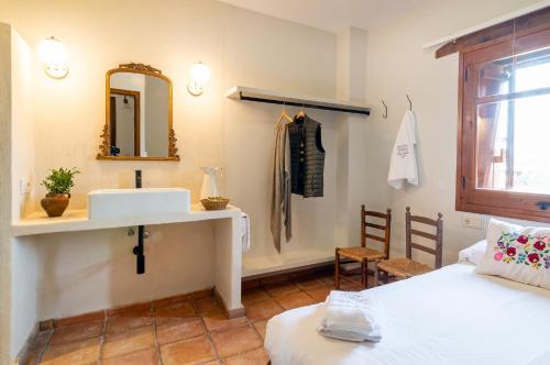 a bathroom with a sink and a mirror and a bed at Casa Joan de Fontsagrada in Fontsagrada