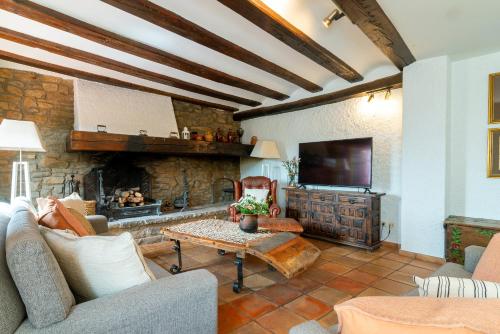 a living room with a couch and a fireplace at Casa Joan de Fontsagrada in Fontsagrada