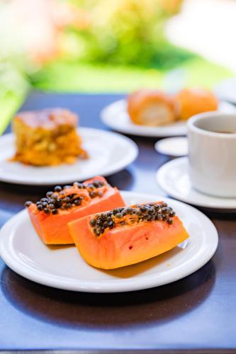 three plates of food on a table with a cup of coffee at Hotel Casa Blanca Porto Seguro in Porto Seguro