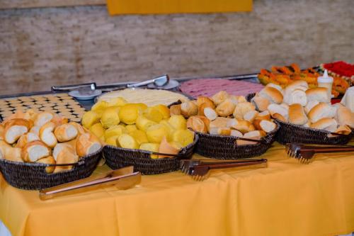 a table with four baskets of different types of food at Hotel Casa Blanca Porto Seguro in Porto Seguro