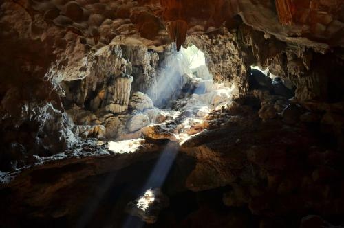 a cave with a shaft of light in it at InterContinental Halong Bay Resort by IHG in Ha Long