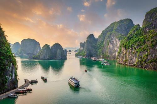 a group of boats on the water in a river with mountains at InterContinental Halong Bay Resort by IHG in Ha Long