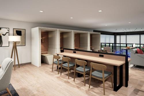 a kitchen and living room with a table and chairs at Atwell Suites Belgrade - Bozeman Airport by IHG in Belgrade