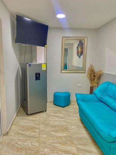 a room with a blue couch and a refrigerator at Habitación luxury villa oti in Ciénaga