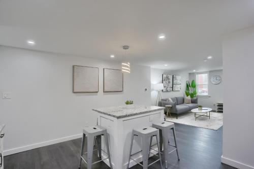 a kitchen and living room with a counter and stools at Stylish and Central 3BD Home Pittsburgh North Side in Pittsburgh