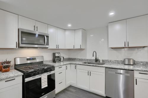 a kitchen with white cabinets and a black stove top oven at Stylish and Central 3BD Home Pittsburgh North Side in Pittsburgh