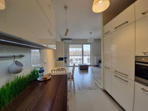 a kitchen with white cabinets and a dining room at Apartament Hetmańska - Parking winda klimatyzacja i najlepsza komunikacja in Łódź