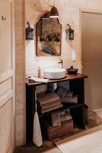 une salle de bain avec un lavabo et un miroir dans l'établissement La Petite Grange des Vignes, à Jumilhac-le-Grand