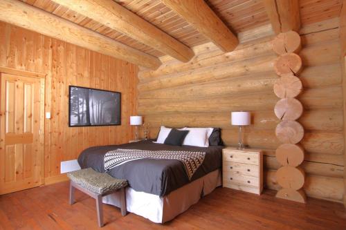 a bedroom with a bed in a wooden wall at Blue Moose Private pool spa sauna lake access in Wentworth