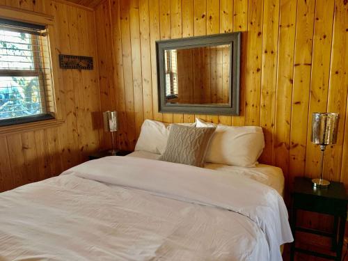 a bedroom with a white bed and a mirror at Blue Moose Private pool spa sauna lake access in Wentworth