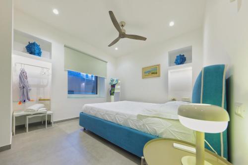 une chambre avec un lit et un ventilateur de plafond dans l'établissement La Casa diLà sul Mare, à Acireale