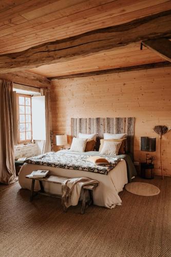 une chambre avec un grand lit dans une pièce en bois dans l'établissement La Petite Grange des Vignes, à Jumilhac-le-Grand