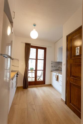 a kitchen with a wooden floor and a door at The Arch Nest in Kavala