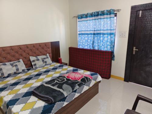 una camera da letto con un letto e una finestra di Shree Dev Kripa Geust house a Ujjain