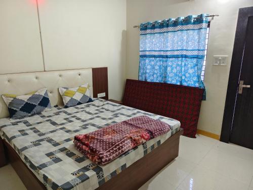 una camera da letto con un letto e una finestra di Shree Dev Kripa Geust house a Ujjain