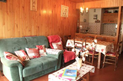 un salon avec un canapé vert et une table dans l'établissement RESIDENCE RSA17 SWIMMING POOL & CENTER 5 pers, à Châtel