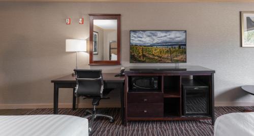 a hotel room with a desk with a computer and a mirror at Prestige Radium Hot Springs Resort, WorldHotels Crafted in Radium Hot Springs