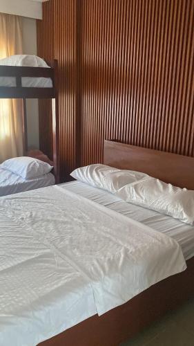 a bedroom with two beds and a wooden wall at CitySouth Premier Inn in Bulatok