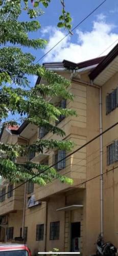 a building with a tree in front of it at CitySouth Premier Inn in Bulatok