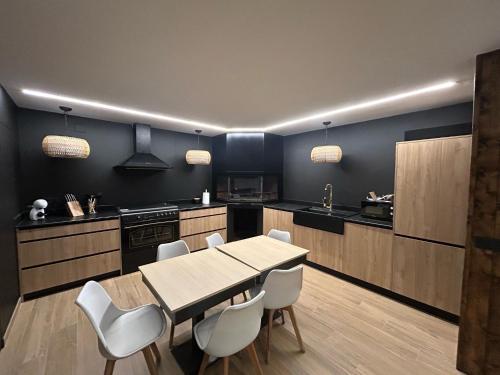 a kitchen with a table and white chairs at CASA MERCEDES-PUERTOMINGALVO in Puertomingalvo