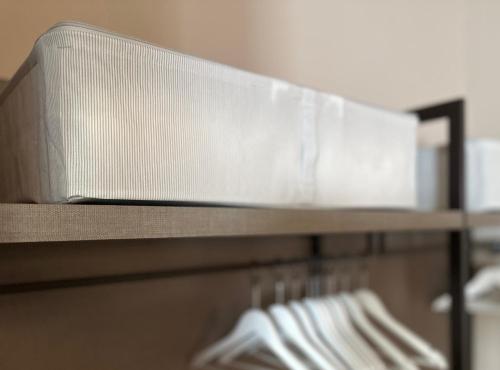 a metal shelf with white towels on it at Alloggi Centrale in Porto Tolle