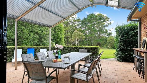 a patio with a table and chairs under a pergola at Misty Creek of Robertson in Robertson