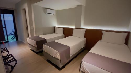 a hotel room with two beds and a couch at Best Guest Hotel Expo Anhembi in Sao Paulo