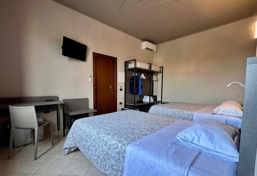a room with two beds and a desk and a computer at Alloggi Centrale in Porto Tolle