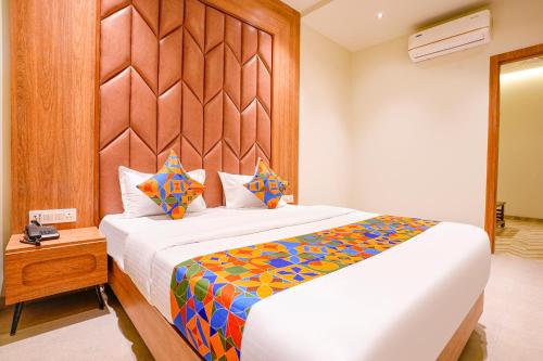a bedroom with a large bed with a wooden headboard at Hotel Regency in Vasai