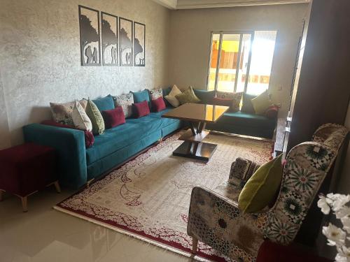 a living room with a blue couch and a table at Appartement de lux avec piscine in Mohammedia